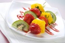 Spiedini di frutta con salsa di cioccolato e granella di noccioline Spiedini di frutta con salsa di cioccolato e granella di noccioline